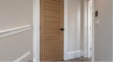 Oak interior door fitted within painted panelling and architrave