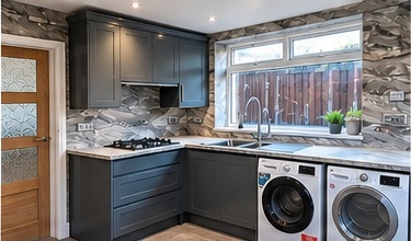 Fitted kitchen and utility area with dark shaker cabinetry, stone splashback and integrated washing machine and dryer by C H Joinery Solutions