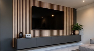 Bespoke media wall with slatted timber panelling and a low floating cabinet by C H Joinery Solutions
