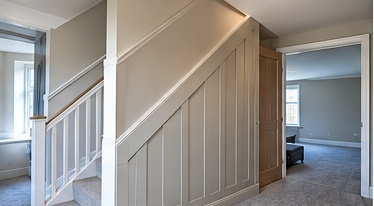 Painted timber stair panelling fitted to a hallway staircase and landing